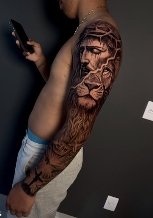 Tatuagem realista de Cristo e leão em braço completo
