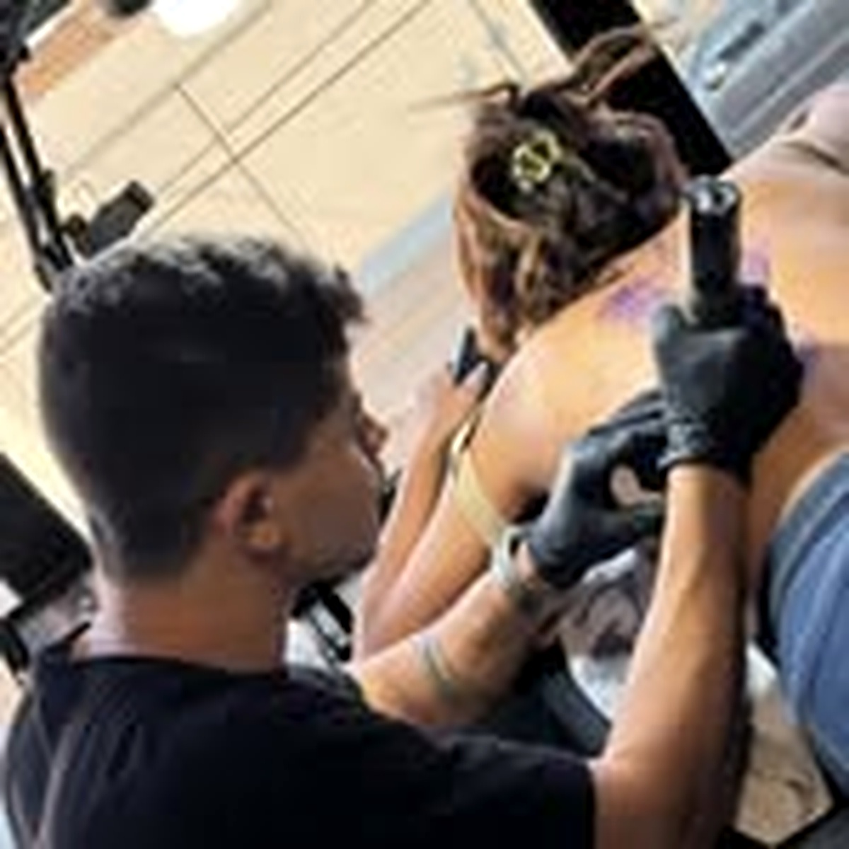 Miqueias Péres durante uma sessão de tatuagem